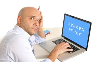 Picture of confused man sitting in front of computer that doesn't work.