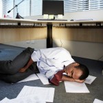 Picture of accountant sleeping under his desk.