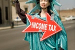 Picture of statute of liberty holding a sign that says income tax