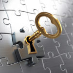 Picture of a key unlocking ia puzzle piece