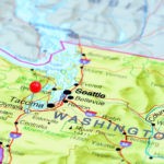 Photo of pinned Olympia on a map of USA. May be used as illustration for travelling theme.
